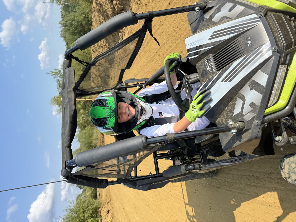 Kind met helm achter het stuur van de Kids Buggy